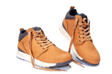 Beyaz arka planda fotoğraflanmış yetişkin bir adam için doğal nubuck derisinden yapılmış zarif spor ayakkabıları..