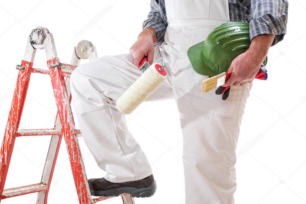 House painter worker on the ladder with white work overalls, keeps the roller to paint in his hand. Equipped with shoes, helmet and protective gloves. Isolated on white background. 