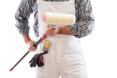 Beyaz tulumlu boyacı, elinde boya yapmak için silindiri tutuyor. Koruyucu eldivenlerle donatılmış. Beyaz arkaplanda izole. 