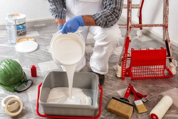 白种人的房屋漆工穿着白色工作服 把油漆倒入容器 建筑业 — 图库照片