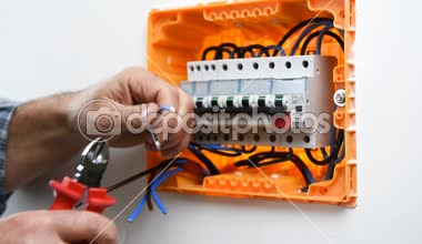 Elektrik kablolarını bir konut kurulumunun elektrik panelinde keserek elektrikçi teknisyeninin ellerinin videosu. İnşaat endüstrisi.