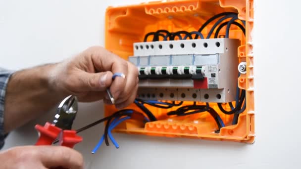 Vidéo des mains du technicien électricien coupant les câbles électriques dans un panneau électrique d'une installation résidentielle. Industrie du bâtiment .