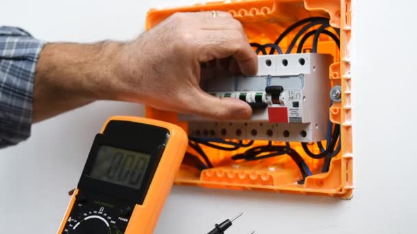 使用万用表测量住宅装置电气开关柜电压的电工技术员的手的视频 建筑行业 — 图库视频影像