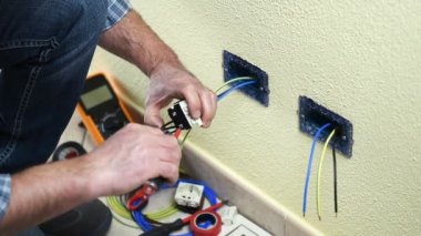 Elektrikçi Teknisyen alt ekler ve bir konut elektrik sistemi elektrik priz kabloları giderir. İnşaat sektöründe. Bina. Görüntüleri. 