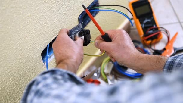 Elektrikář technik pracovník vloží a řeší kabely elektrické zásuvky bytové elektrického systému. Stavební průmysl. Budova. Záběry. 