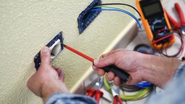 Elektrikçi teknisyeni işçi bir konut elektrik sistemi elektrik soketine birimin bağlantısını keser. İnşaat sektöründe. Bina. Görüntüleri