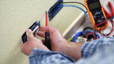 Elektrikçi teknisyeni işçi bir konut elektrik sistemi elektrik soketine yükleyin. İnşaat sektöründe. Bina. Görüntüleri. 