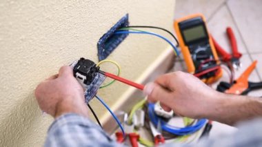 Elektrikçi Teknisyen alt ekler ve bir konut elektrik sistemi elektrik priz kabloları giderir. İnşaat sektöründe. Bina. Görüntüleri. 