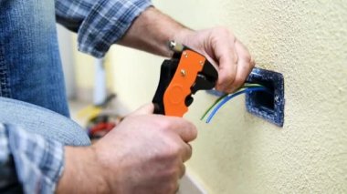 Elektrikçi Teknisyen alt tel striptizci pense ile elektrik kablo konut elektrik sisteminde hazırlar. İnşaat sektöründe. Bina. Görüntüleri. 