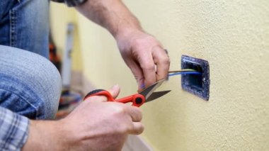 Elektrikçi teknisyeni işçi profesyonel makas ile elektrik kablo konut elektrik sisteminde hazırlar. İnşaat sektöründe. Bina. Görüntüleri. 
