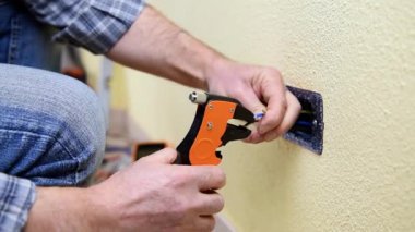 Elektrikçi Teknisyen alt tel striptizci pense ile elektrik kablo konut elektrik sisteminde hazırlar. İnşaat sektöründe. Bina. Görüntüleri. 