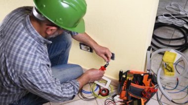 Elektrikçi teknisyeni işçi elektrik kablo konut elektrik sisteminde hazırlar. İnşaat sektöründe. Bina. Görüntüleri. 