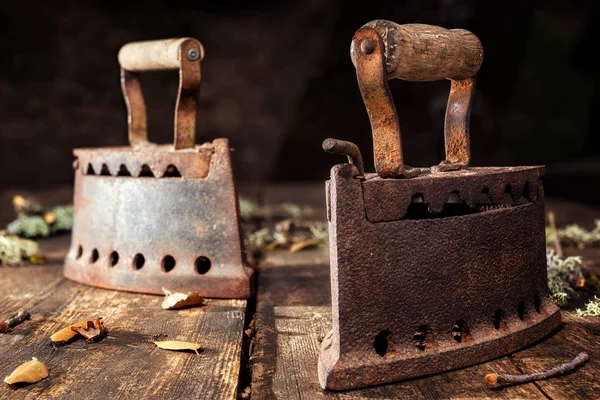 Ferro enferrujado velho em uma mesa de madeira rústica. Passar a ferro . — Fotografia de Stock