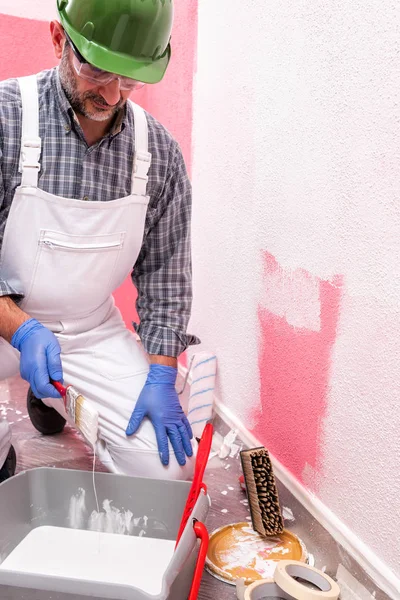 Trabajador pintor de casa en el trabajo en el sitio de construcción. Edificio . — Foto de Stock