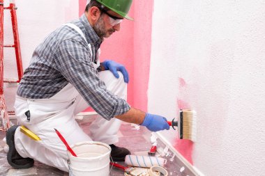 Şantiyede iş yerinde ev boyacısı. Bina.