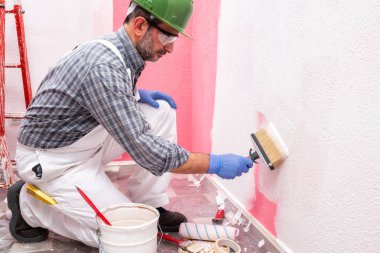 Şantiyede iş yerinde ev boyacısı. Bina.