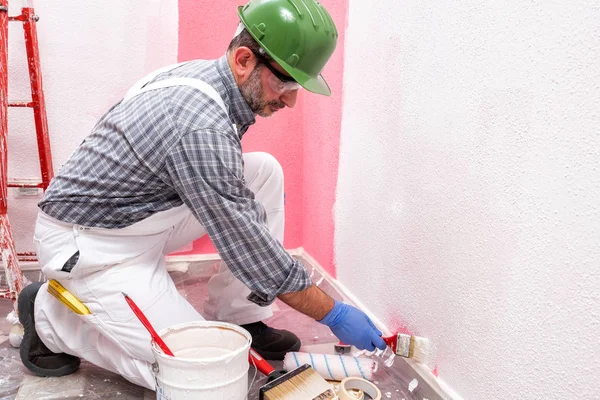 Huisschilder werknemer aan het werk op de bouwplaats. Gebouw. — Stockfoto