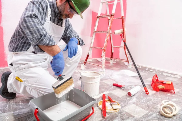 Trabajador pintor de casa en el trabajo en el sitio de construcción. Edificio . — Foto de Stock