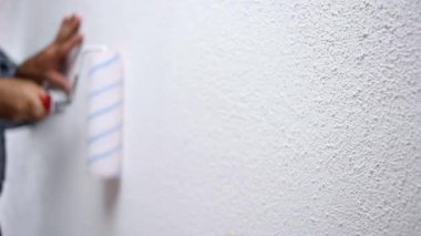 Beyaz bir duvarüzerinde rulo işleri ile Kafkas ev ressam işçi. İnşaat sektörü. Görüntü.