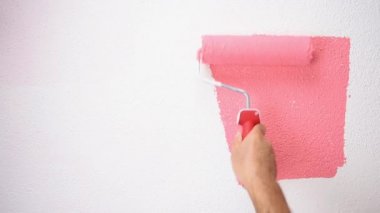 Rulo ile Kafkas ev ressam işçi pembe renk boyama ile duvar boyalar. İnşaat sektörü. Görüntü.