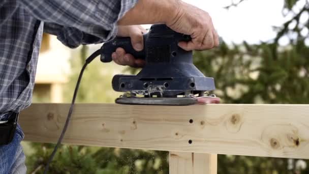Carpinteiro Adulto Artesão Com Lixadeira Elétrica Suaviza Placas Uma Cerca — Vídeo de Stock