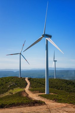 Sardunya 'daki bir dağ rüzgâr çiftliğinde güzel mavi bir gökyüzünde rüzgar türbinleri. Yenilenebilir enerji konsepti, yeşil enerji üretimi. Enerji endüstrisi.
