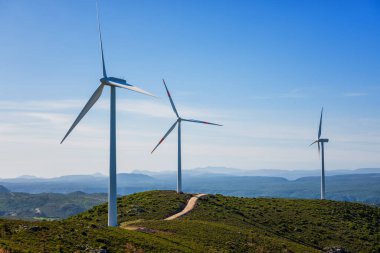 Sardunya 'daki bir dağ rüzgâr çiftliğinde güzel mavi bir gökyüzünde rüzgar türbinleri. Yenilenebilir enerji konsepti, yeşil enerji üretimi. Enerji endüstrisi.