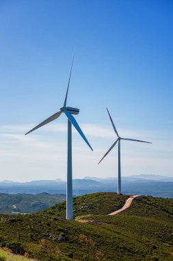 Sardunya 'daki bir dağ rüzgâr çiftliğinde güzel mavi bir gökyüzünde rüzgar türbinleri. Yenilenebilir enerji konsepti, yeşil enerji üretimi. Enerji endüstrisi.