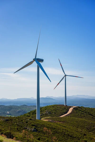 Sardunya 'daki bir dağ rüzgâr çiftliğinde güzel mavi bir gökyüzünde rüzgar türbinleri. Yenilenebilir enerji konsepti, yeşil enerji üretimi. Enerji endüstrisi.