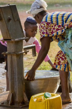 Gana, Accra - 02 Ocak 2017: Afrika Gana kız annesi ile al Su kuyu Accra, Gana