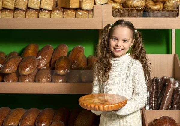 Kleines Mädchen Mit Brot Der Hand Vor Regalen Mit Verschiedenen — Stockfoto