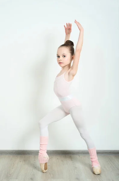 一位可爱的年轻芭蕾舞演员在家里的地板上做芭蕾舞姿势和伸展运动 — 图库照片