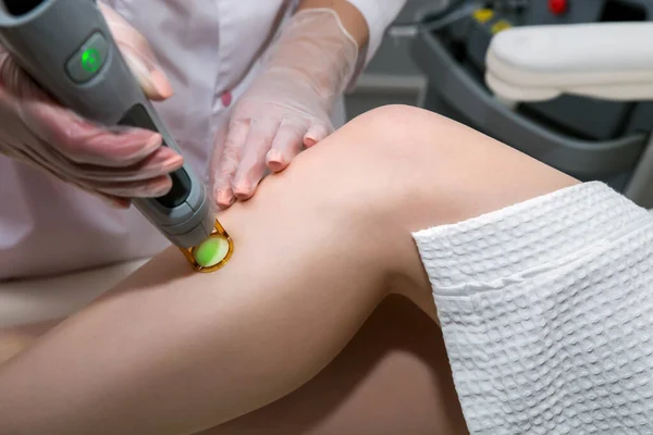 Hair removal cosmetology procedure from a therapist at cosmetic beauty spa clinic. Laser epilation and cosmetology.