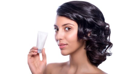 Elinde beyaz temiz krem tüpü olan genç ve güzel bir manken. Taze ciltli genç bir kadın. Model yap. Gençlik ve Deri Bakımı Konsepti. Spa ve Sağlık. Makyaj ve Saç.