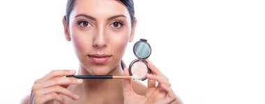 Profesyonel makyajlı ve uzun kirpikli güzel bir kadın kozmetik makyaj ürünüyle fırça tutuyor. Spa, cilt bakımı ve sağlık. Çıplak doğal makyaj ve uzun takma kirpiklerle. Kopyalama alanı.