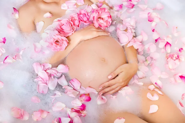 Красивая Беременная Молодая Женщина Заботится Своем Животе Пенной Ванне Цветами — стоковое фото