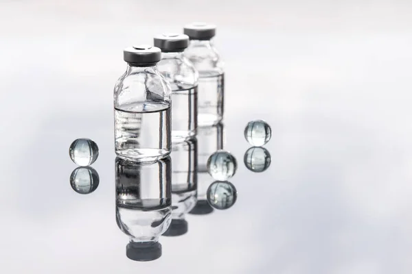 Set of transparent medical bottles and bottles with liquid with different transparent balls.Concept of medical,  pharmaceutical, cosmetological technology.