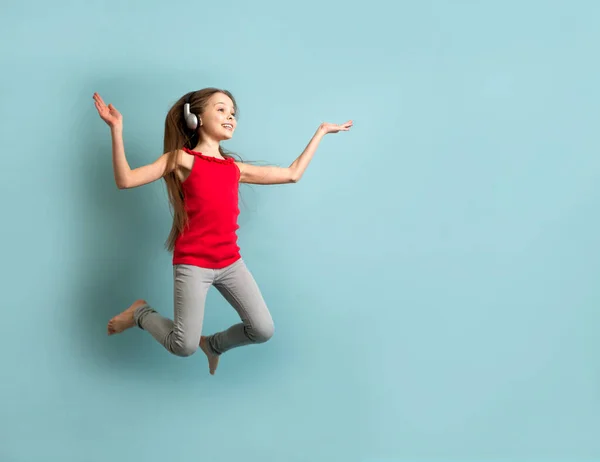Маленькая Веселая Девочка Длинными Волосами Серых Наушниках Слушает Музыку Танцует — стоковое фото