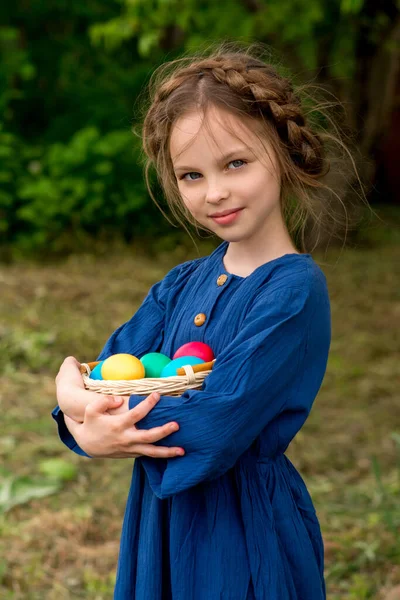 Paskalya Yumurtalarını Sepete Koyup Bahçede Elini Sallayarak Gülümseyen Küçük Kız — Stok fotoğraf
