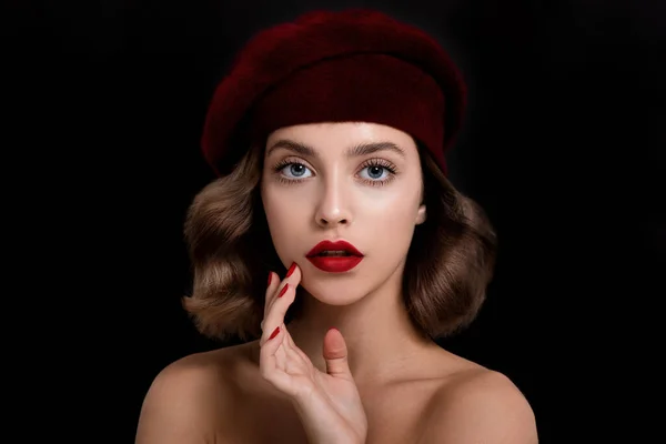 完璧な若い肌 赤いマットの唇や爪と赤い服やベレー帽を身に着けている美しい若い女性の肖像画 明るい緋色の色の化粧とマニキュアを持つモデルは 暗い背景にポーズ — ストック写真