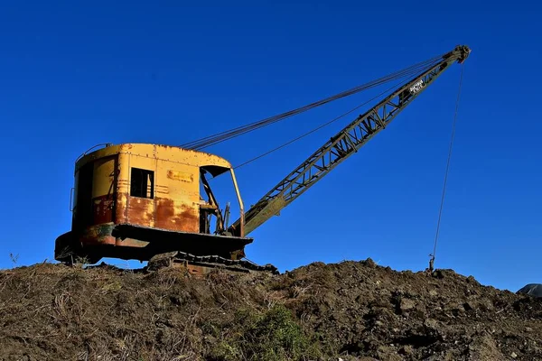 Una Vecchia Gru Arrugginita Poggia Enorme Mucchio Terra Con Una — Foto Stock