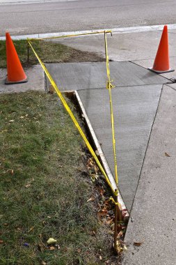 Bir kaldırım onarım proje sarı uyarı şerit ve turuncu konileri tarafından çevrilidir. 