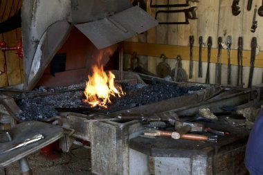 Kırmızı sıcak demirhane ve araçları bir tezgah üzerinde döşeme alevlerden bir Demirci dükkanında bulundu