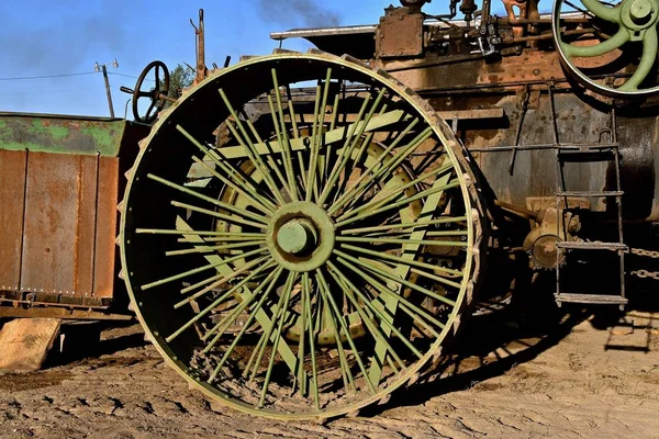 The spokes  from the wheel are reinforced with three bars on  a large steam engine.