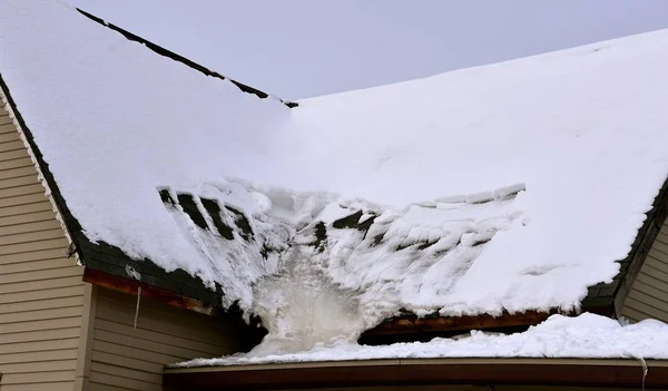 Melted snow on a roof has created an ice sheet frozen at an angle