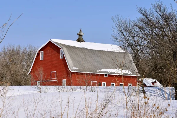 一个寒冷的场景 一个红色的老臀部屋顶谷仓的屋顶和冲天炉上有雪 — 图库照片