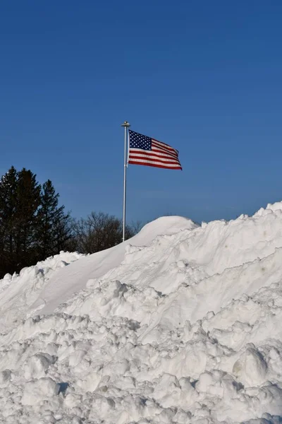 アメリカ合衆国旗が風で吹く雪の巨大な山に囲まれ — ストック写真