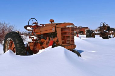 Barnesville, Minnesota, 11 Mart 2019: Eski bir yıpranmış M traktör kısmen derin kar gömüldü Farmall kış kar fırtınaları tarafından yaptı. 
