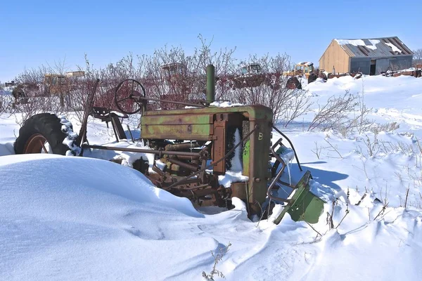 在冬天的暴风雪过后 打捞和垃圾场里的拖拉机被部分埋在深雪中 — 图库照片