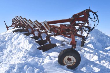 Eski bir yedi alt pulluk bir yol kurtarma ve hurdalık kaldırılan kardan büyük bir yığın üstüne yatıyor.